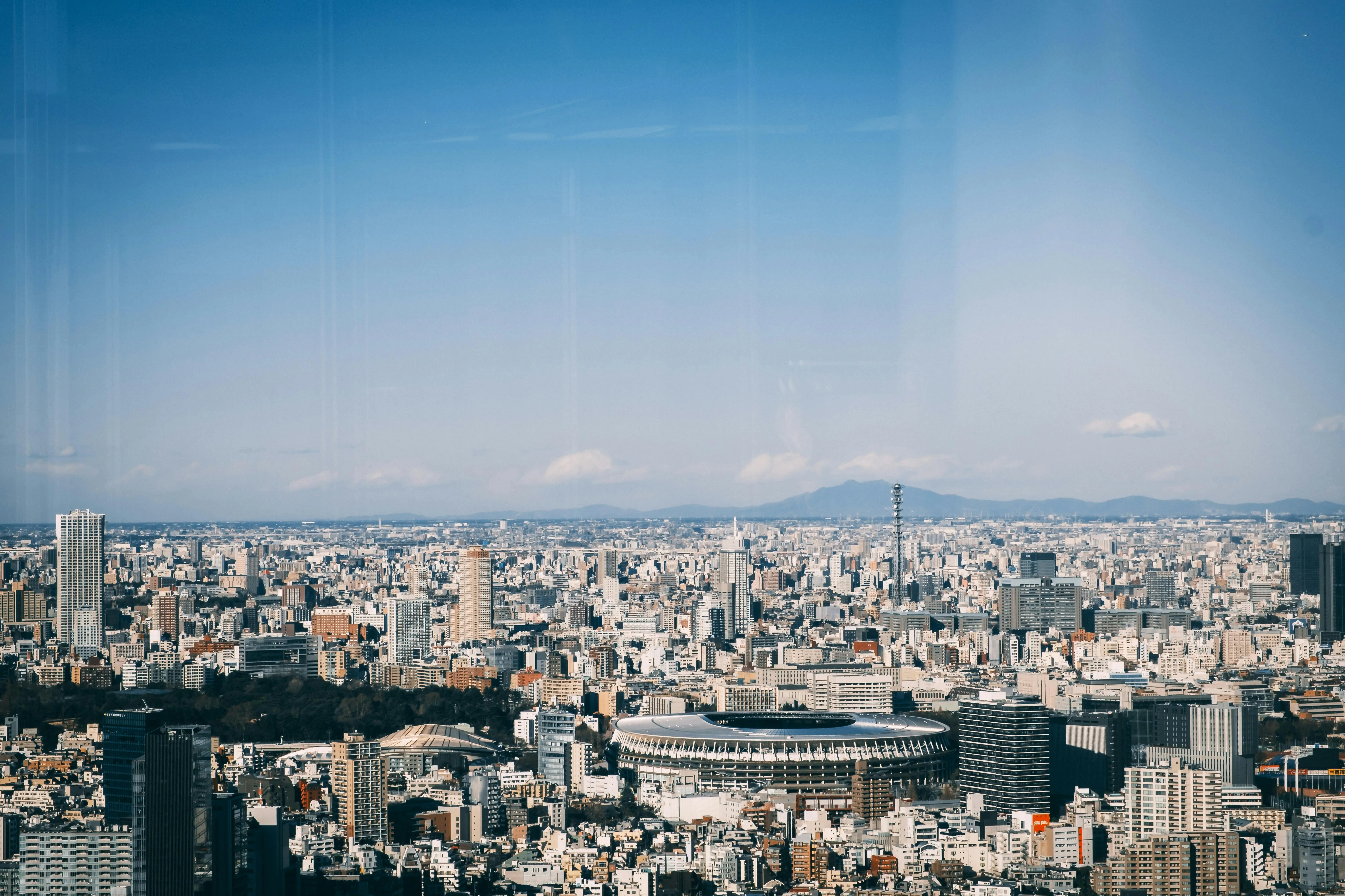 A breathtaking aerial perspective of Tokyo, captured from the rooftop of a building, highlighting the city's dynamic urban landscape.
